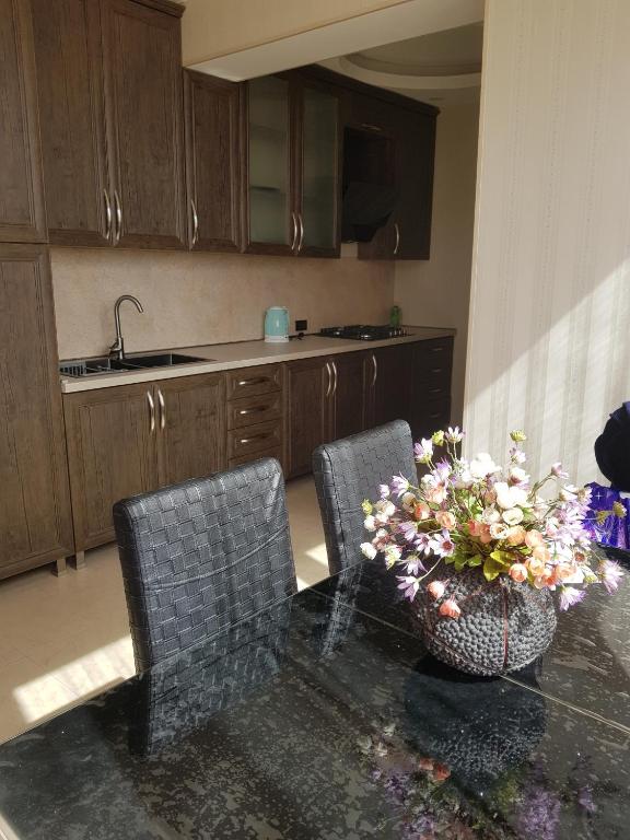 una cucina con un tavolo con sedie e un vaso di fiori di Isani Panorama a Tbilisi City
