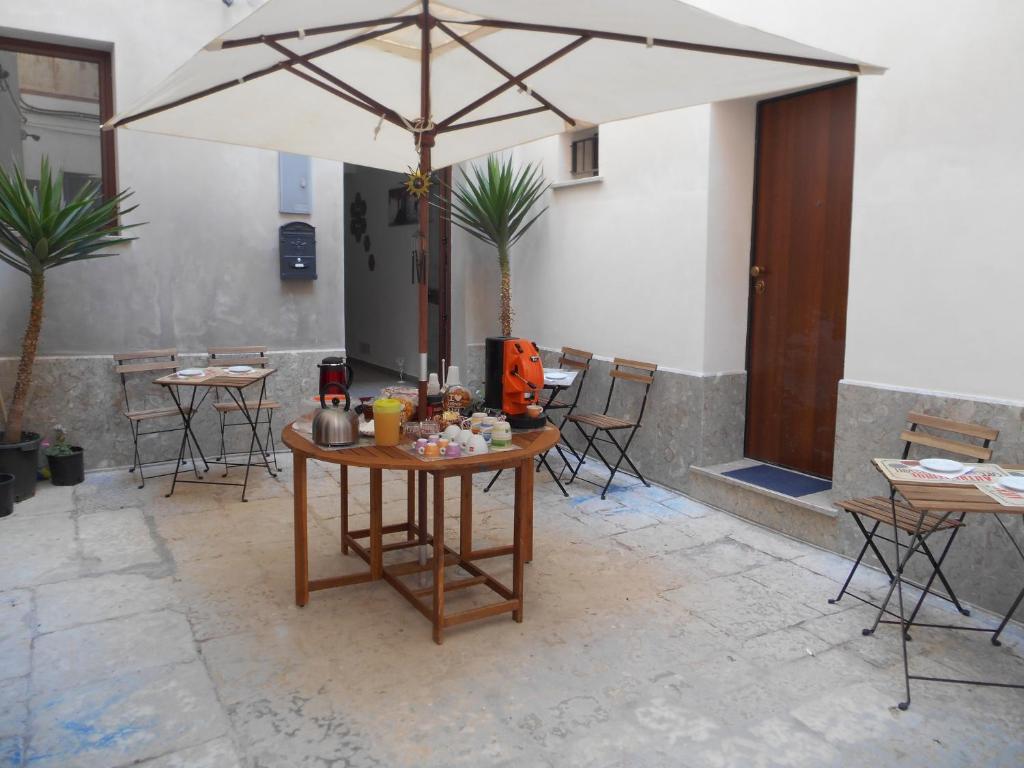 un tavolo con ombrellone su un patio di La Corte Dei Naviganti a Trapani