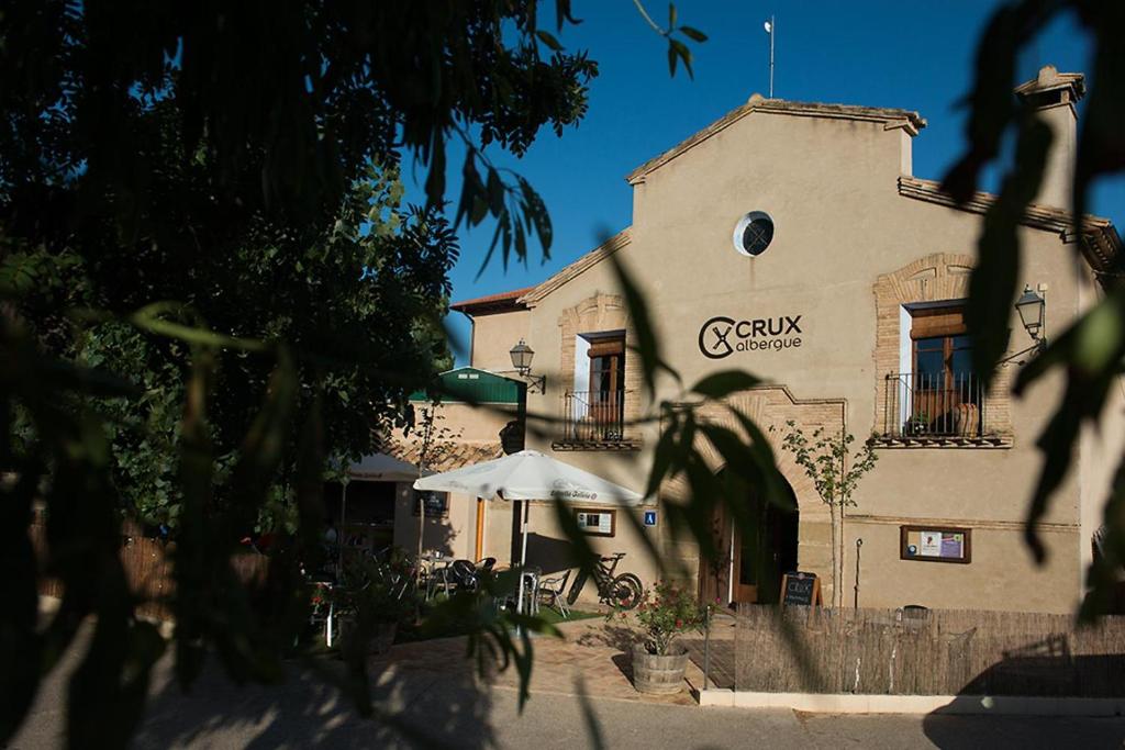 un edificio con una sombrilla delante de él en Crux Albergue en Adahuesca