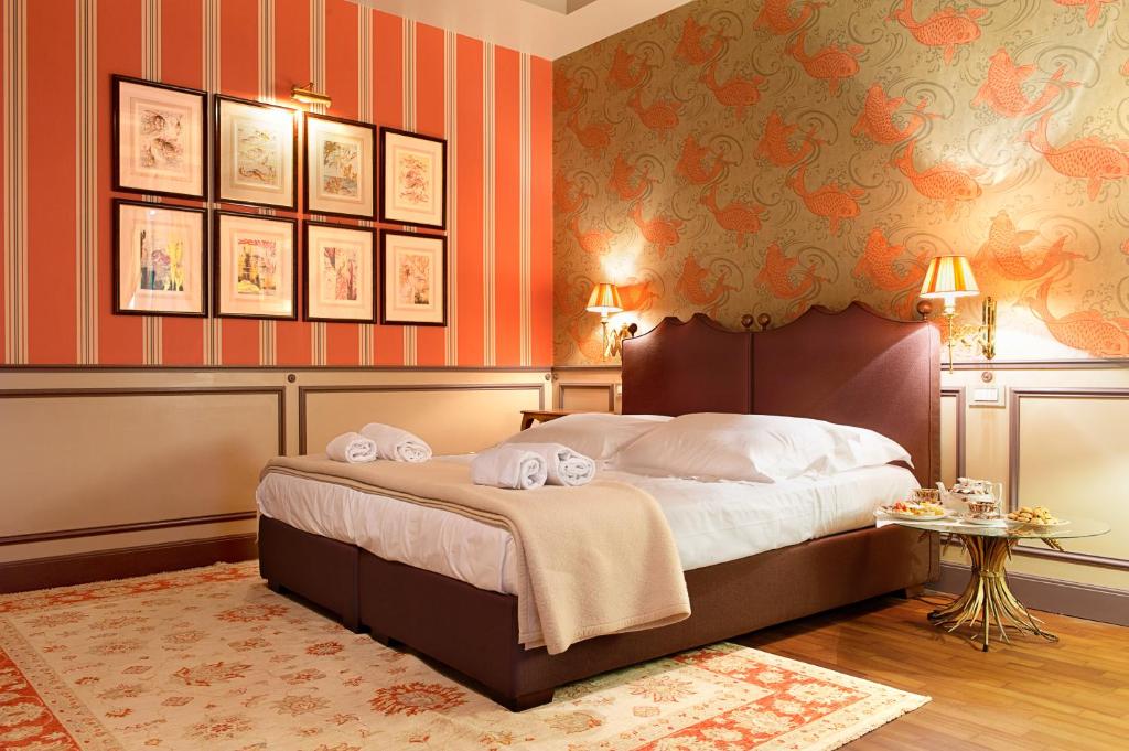 sypialnia z dużym łóżkiem z pomarańczowymi ścianami w obiekcie Residenza Borsari w Weronie