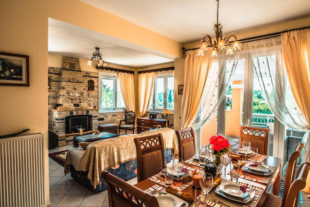 a dining room with a table and chairs and a living room at Villa Miranda in Gouvia