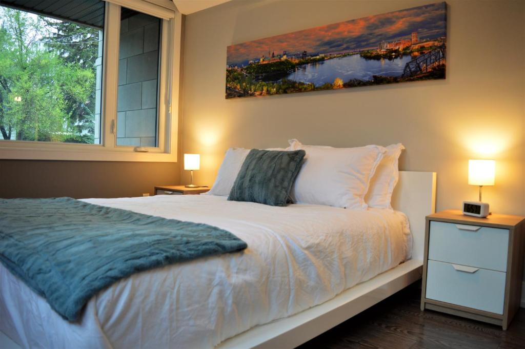 a bedroom with a bed and a large window at Simply Luxury Stays in Ottawa