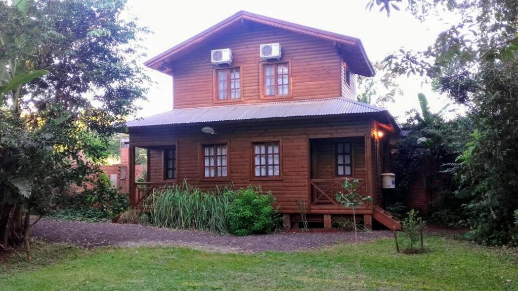 a large wooden house with windows on a yard at Posada de los Árboles in Eldorado