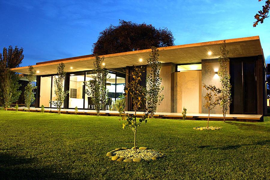una casa con un árbol en medio de un patio en Casa en Club de Campo en San Nicolás de los Arroyos