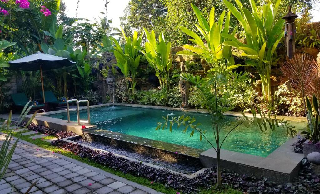 einen Pool inmitten eines Gartens in der Unterkunft Sari Mimpi Kutuh in Ubud