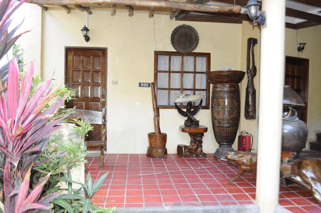 a room with a red tiled floor in a house at Casa Aviara Resort & Hotel in Puerto Galera