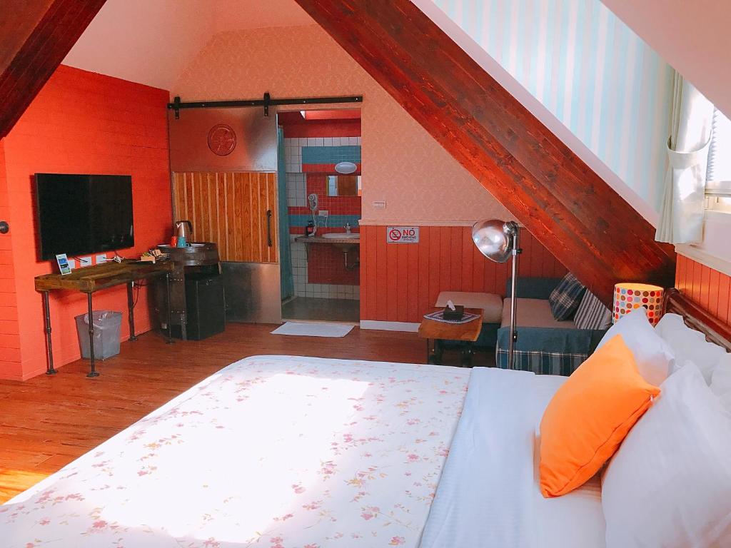a bedroom with a large bed and a kitchen at MiCarro B&amp;B in Dongshan