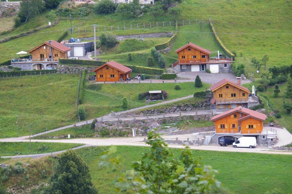 eine Gruppe von Häusern auf einem Hügel mit einer Straße in der Unterkunft Chalet Helalph in La Bresse