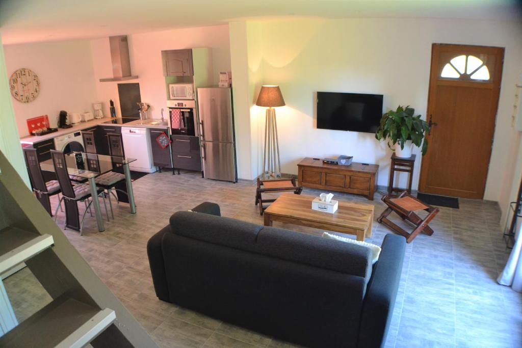 uma sala de estar com um sofá e uma cozinha em Sur la route de champ colin em Saint-Denis-lès-Rebais