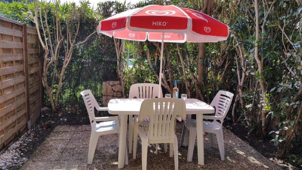 ヴィルヌーヴ・ルベにあるRésidence Cap Azur Appartement 229の赤い傘付きテーブルと椅子