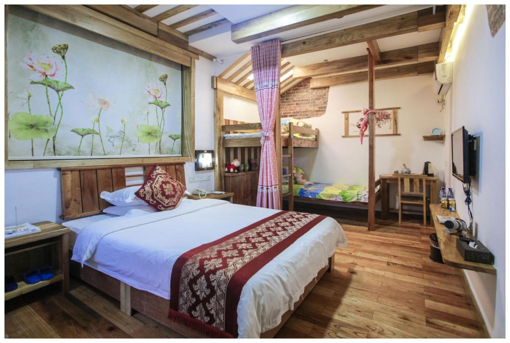 um quarto com uma cama e uma televisão num quarto em Zhangjiajie Wangyi Inn em Zhangjiajie