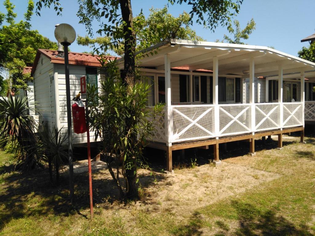 Uma casa branca com uma caixa de correio vermelha à frente. em AdriaCamp Mobile Homes Cavallino em Cavallino-Treporti