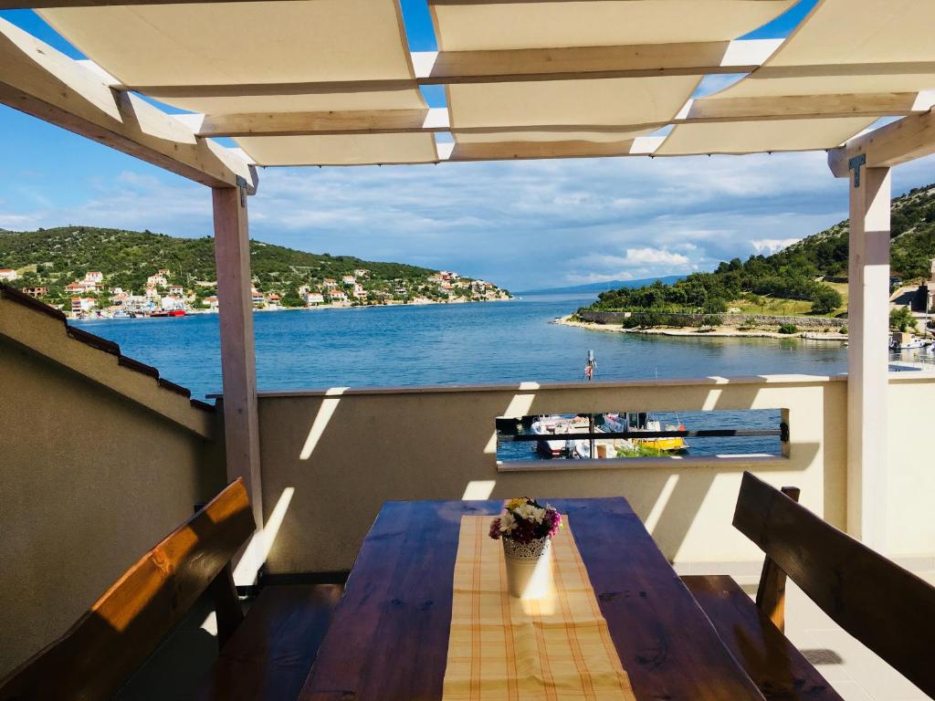 een tafel op een balkon met uitzicht op het water bij Apartment Pika Smokvina 2a in Vinišće