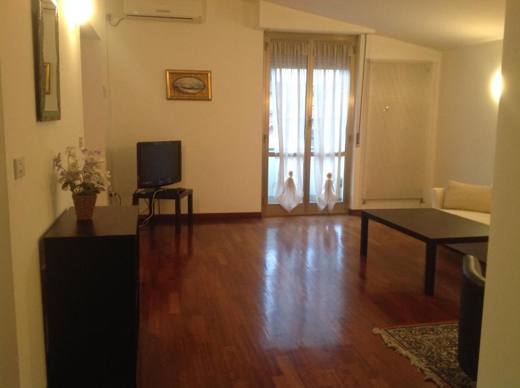 uma sala de estar com piso de madeira e uma televisão em SEA STAR Holidays House - Beach 150 m - Private parking em Pescara