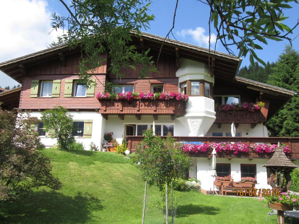 Una casa en una colina con flores. en Haus Romantika en Schattwald