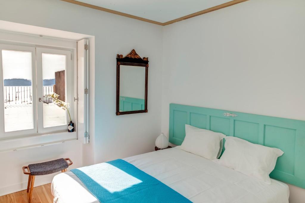 a bedroom with a blue and white bed and a window at Palácio Camões - Lisbon Serviced Apartments in Lisbon