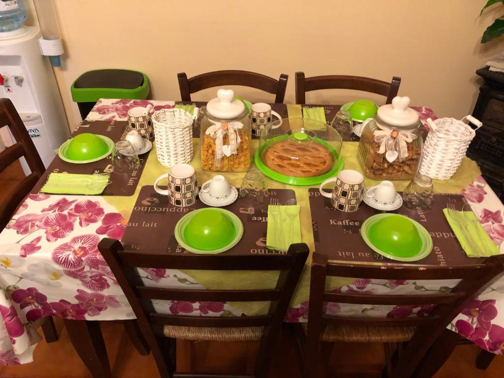 stół jadalny z zielonymi daniami w obiekcie B&B Le Mille E Una Notte w mieście Olbia