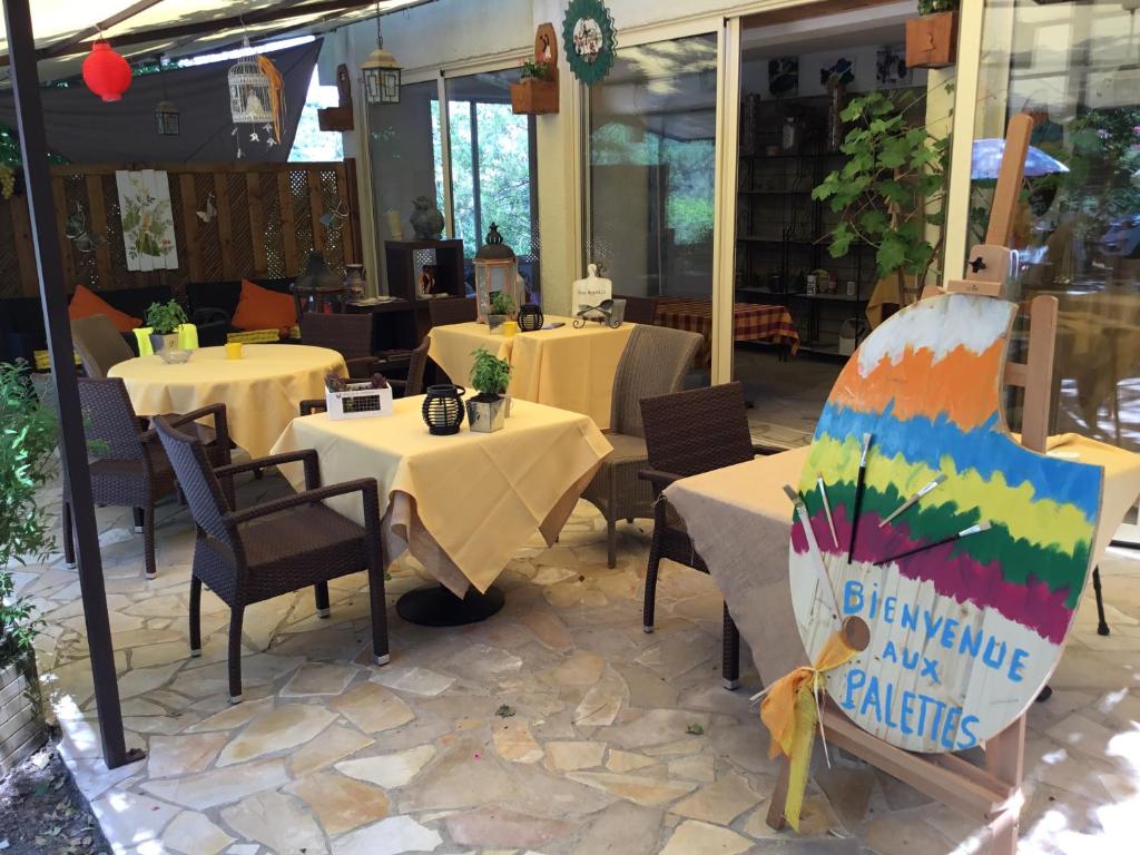 サラヴァにあるLes Palettesのテーブルと椅子が2脚あるレストランと看板