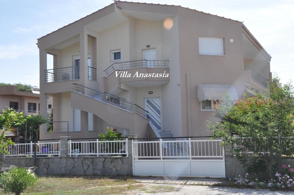 a white building with a balcony and a sign on it at Villa Anastasia in Keramoti
