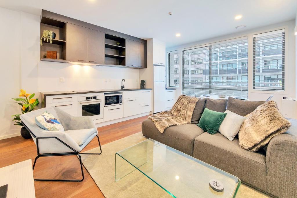 uma sala de estar com um sofá e uma mesa em Designer Styled City Apartment with Carpark em Auckland