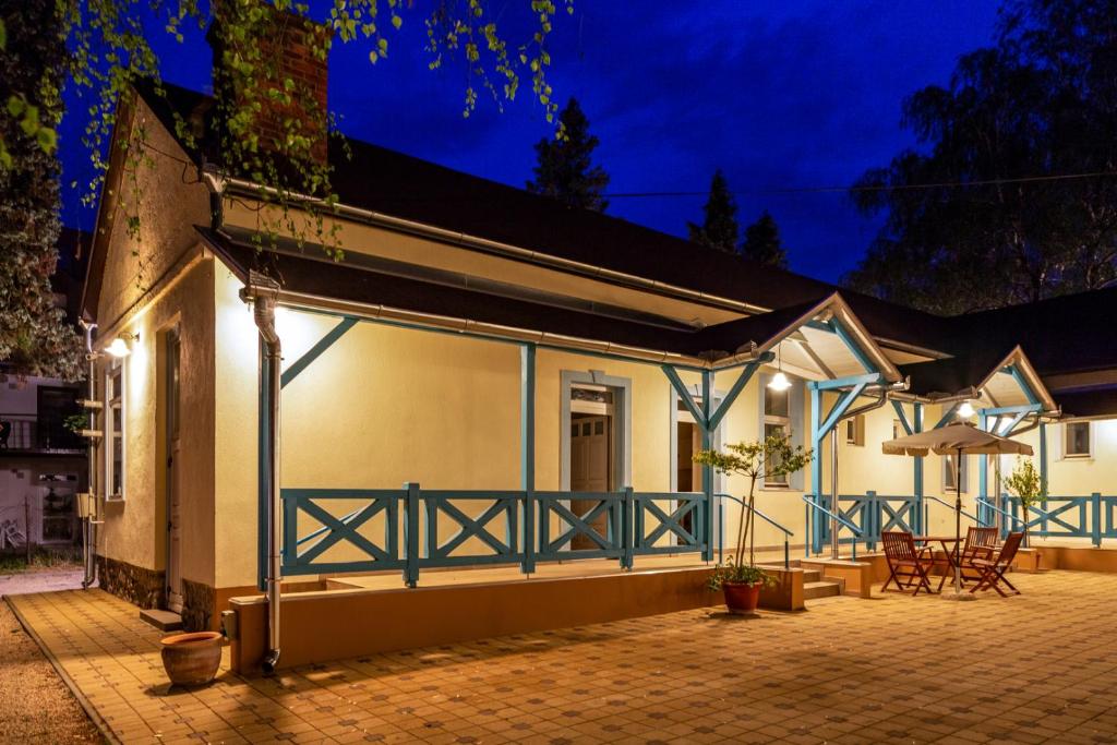 een huis met een blauwe leuning en een patio bij Balzsam apartmanház in Harkány