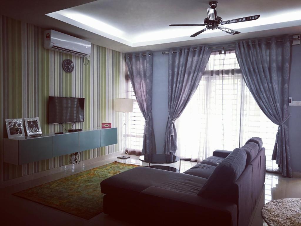a living room with a couch and a large window at Arianna Homestay in Pasir Gudang