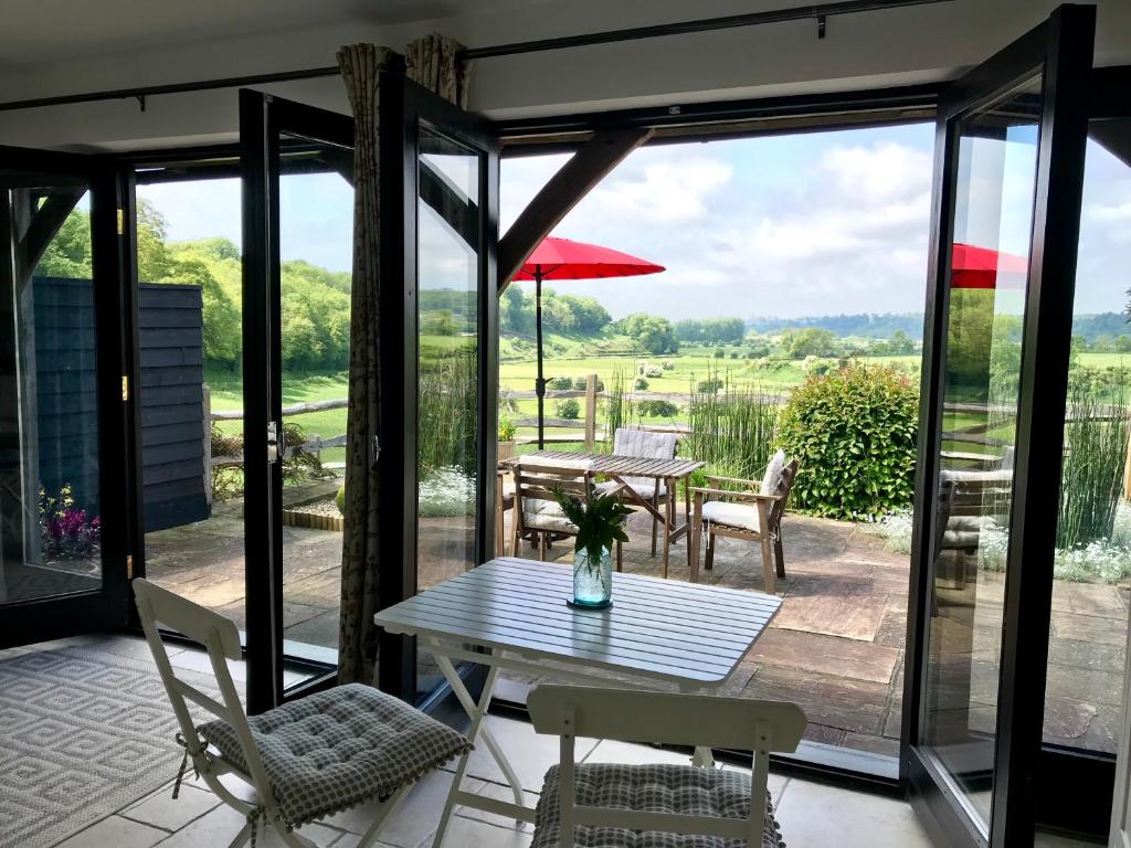 a patio with a table and chairs and a view of a field at The Cow Hide in Arundel