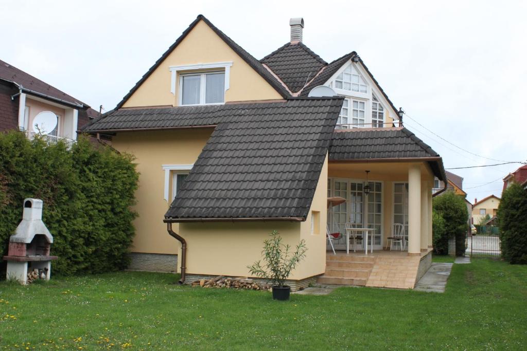 una casa amarilla con techo negro en Orwa Vendégház, en Zalakaros