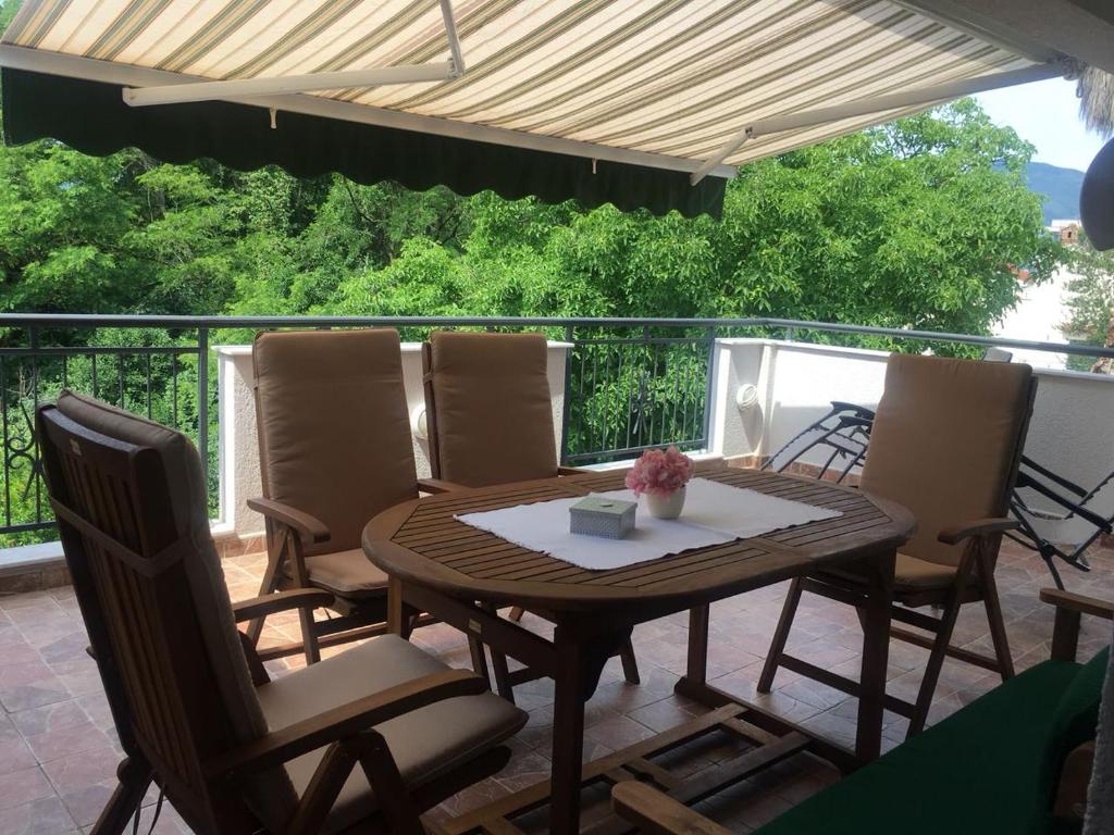 a wooden table and chairs on a patio at Apartmani Stipanic Tivat in Tivat
