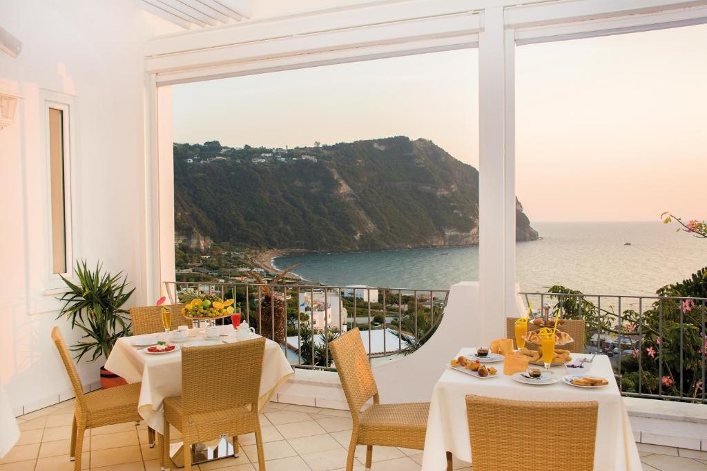 a dining room with a view of the ocean at Hotel Capizzo in Ischia