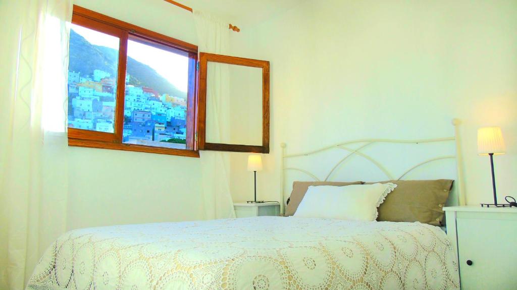 Un dormitorio con una cama blanca y una ventana. en Apt. Lourdes, close to the Teresitas & Anaga, en San Andrés