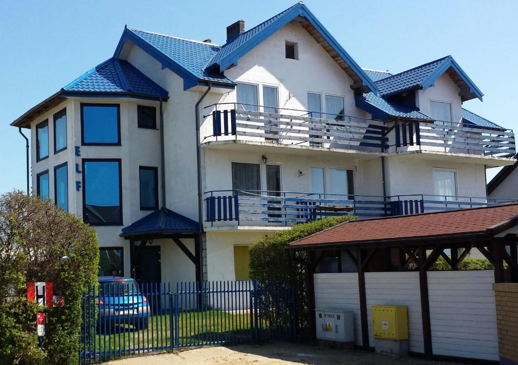 ein großes weißes Haus mit blauem Dach in der Unterkunft Willa Elf in Karwia