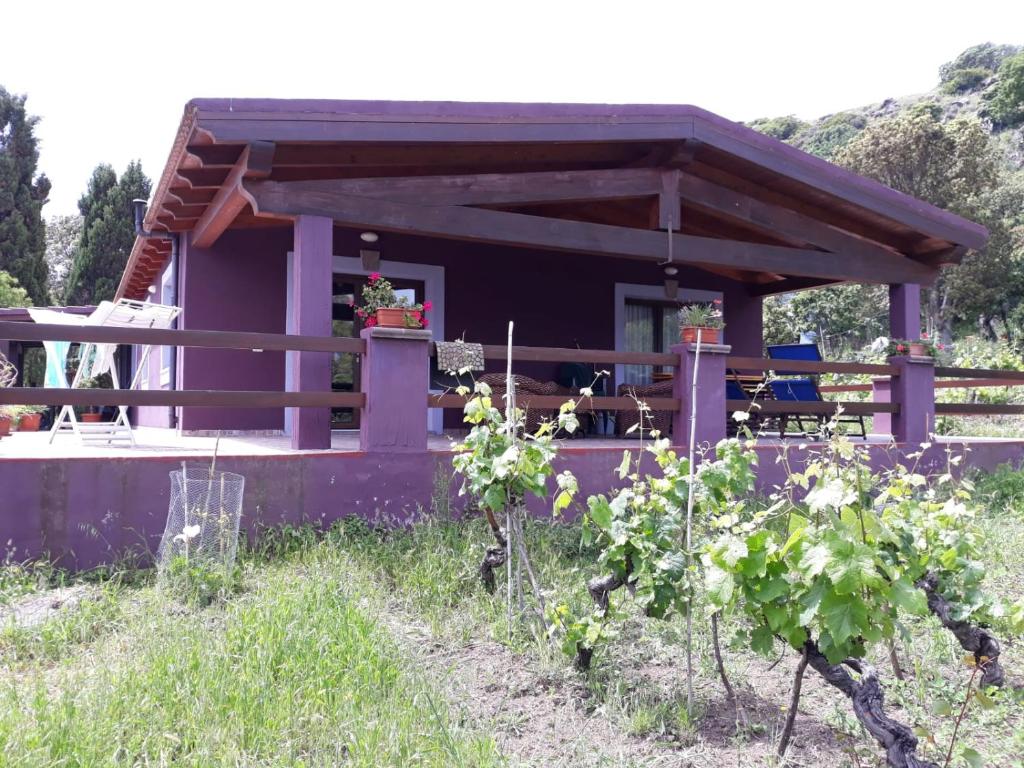 una pequeña casa púrpura con mesa y sillas en Villa Veronica, en Sedini