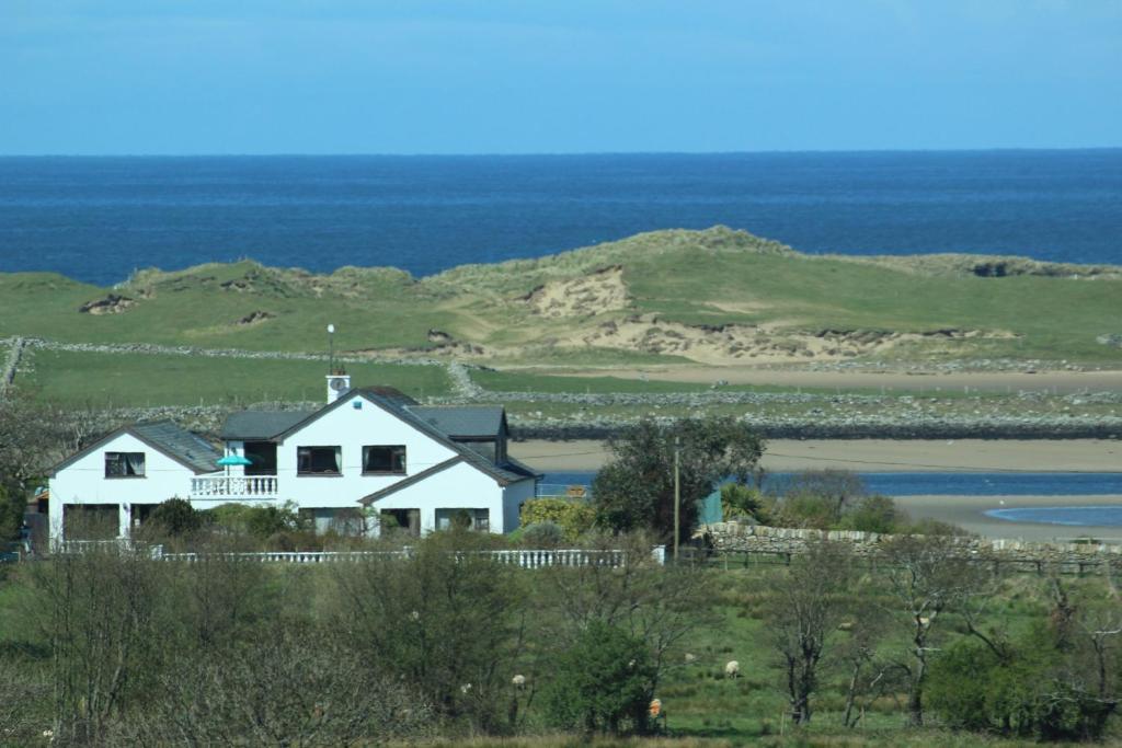 una casa en una colina con el océano en el fondo en Armada Lodge Seashore Holiday Apartment, en Grange