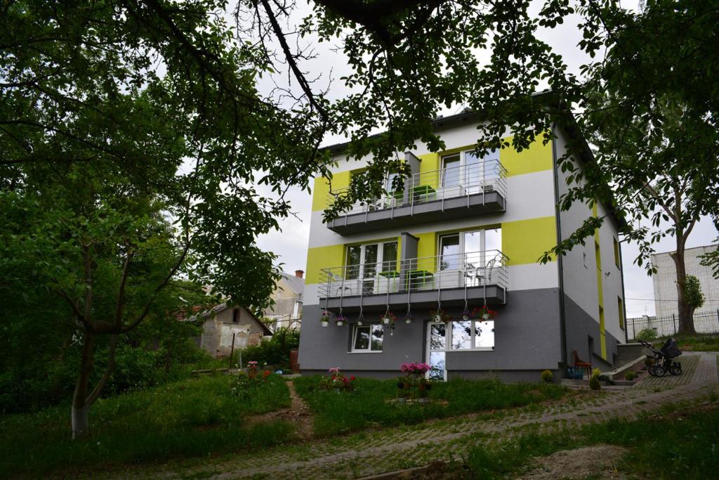a yellow and white building with a balcony at Guest House at Lesya Ukrainka in Truskavets
