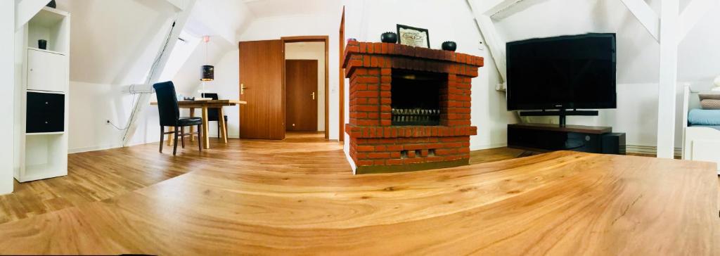 a living room with a wooden floor and a fireplace at Altstadtmärchen in Leer