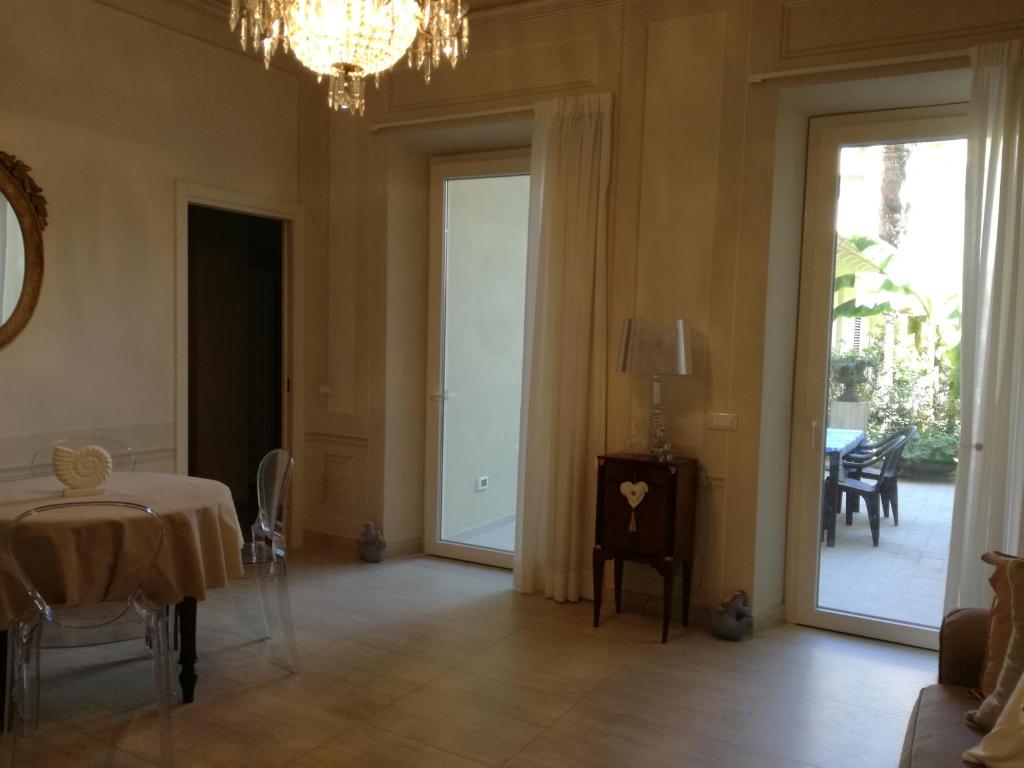 een eetkamer met een tafel en een kroonluchter bij La casa di Anna in Viareggio