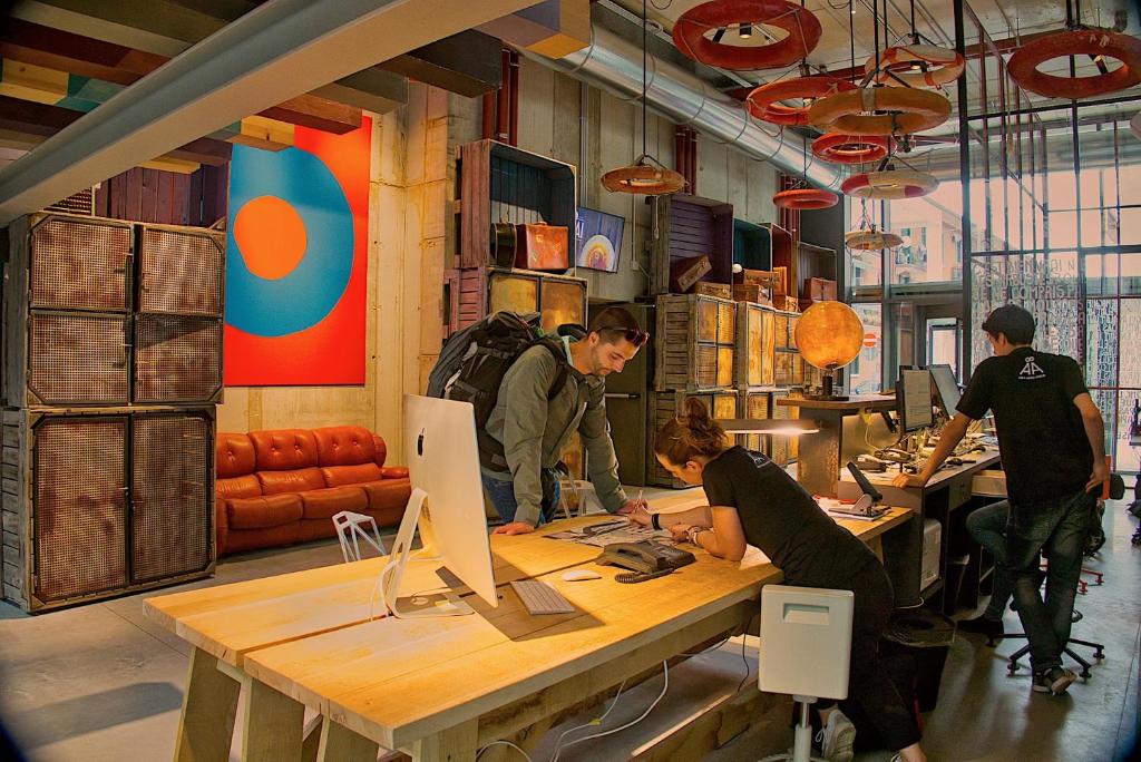 a group of people working at a table with a computer at Anda Venice Hostel in Mestre