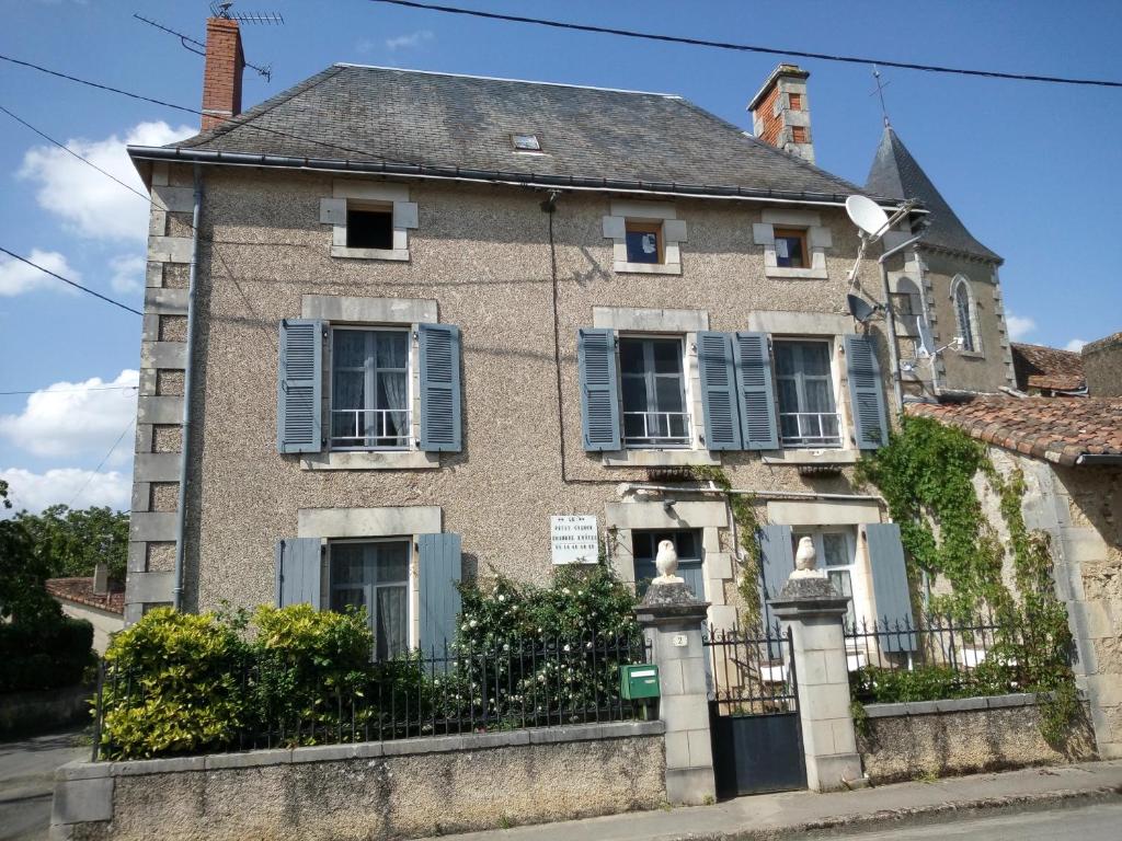 an old house with blue shutters on a street at Le Petit Cochon chambre d` hotes in Haims