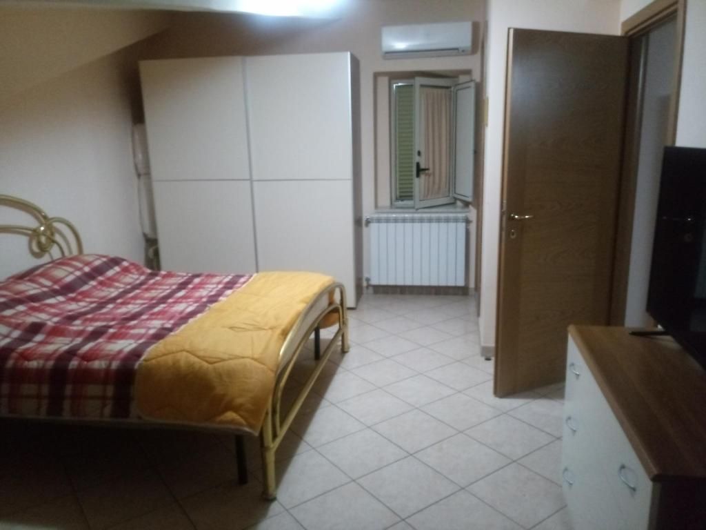ein Schlafzimmer mit einem Bett und einem TV in einem Zimmer in der Unterkunft B&B Mansarda in Caserta