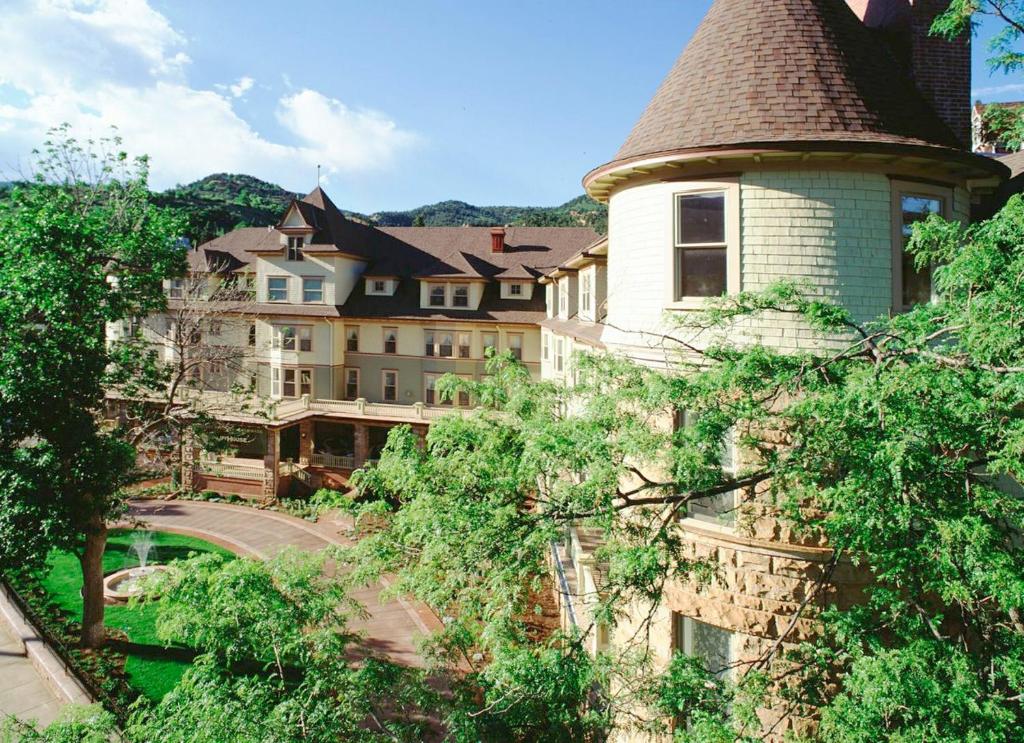 un grand bâtiment avec une tour et un pont dans l'établissement Cliff House at Pikes Peak, à Manitou Springs