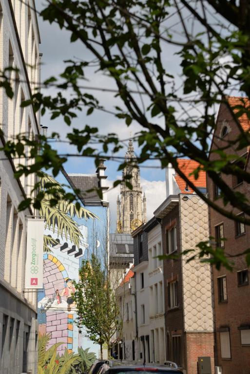 une rue de la ville avec une tour de l'horloge au loin dans l'établissement Huize Amoras, à Anvers