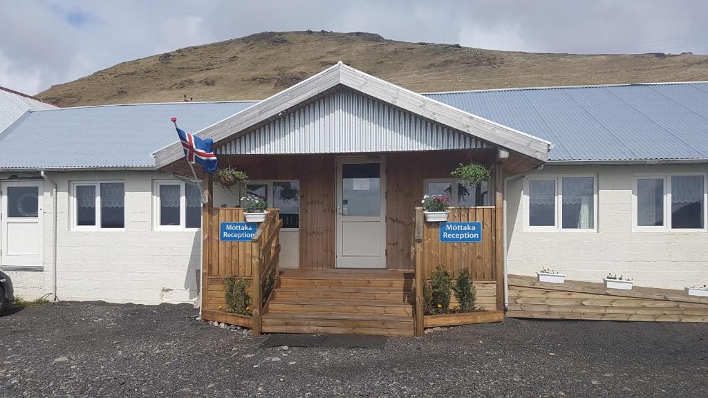 ein Haus mit einer Veranda mit einem Schild darauf in der Unterkunft Hótel Búrfell in Vík
