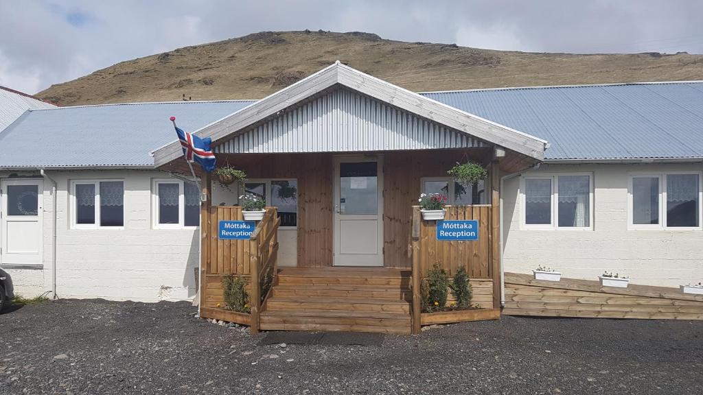 una casa con un portico con un cartello sopra di Hótel Búrfell a Vík