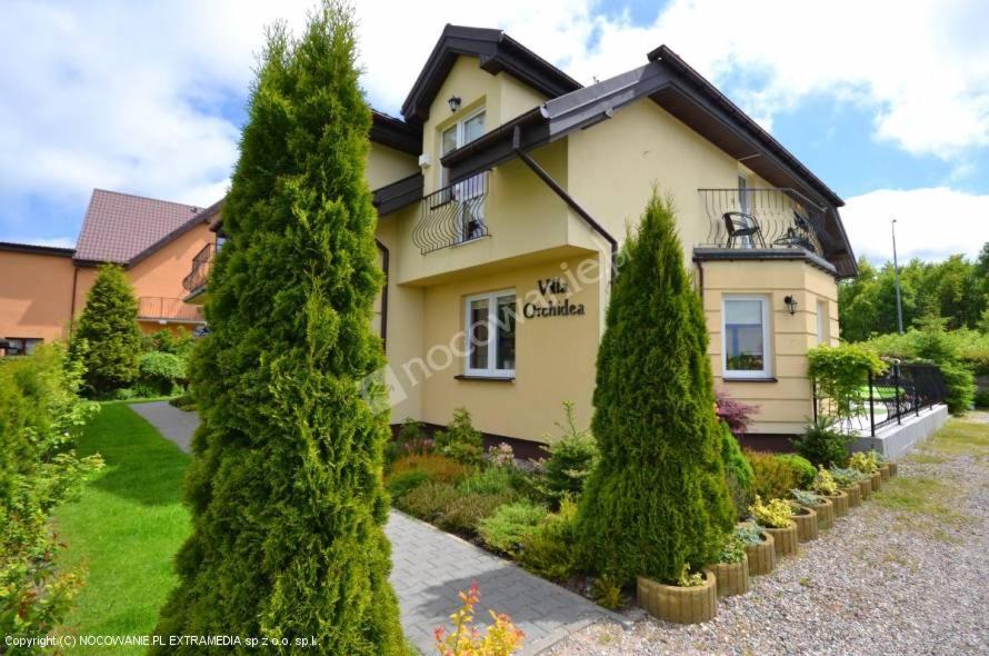 a house with trees in front of it at Villa Orchidea in Grzybowo