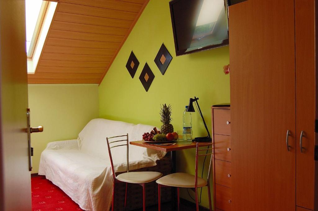 sypialnia z łóżkiem, stołem i krzesłami w obiekcie Villa Orchidea w Grzybowie