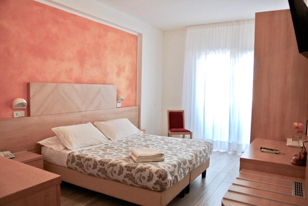 a bedroom with a bed and a large window at Hotel Bologna in Lignano Sabbiadoro