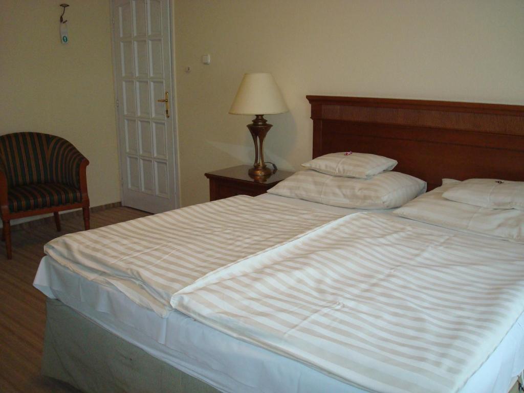 Postel nebo postele na pokoji v ubytování Hotel Romantik Eger