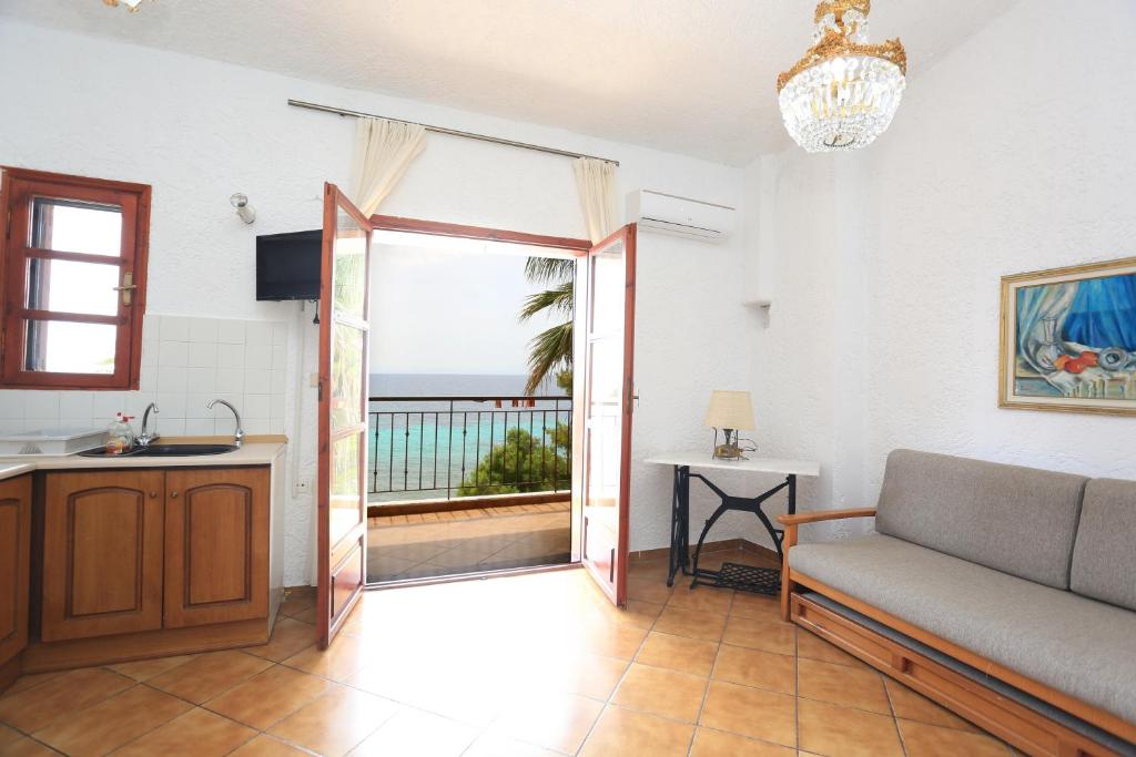 a living room with a door open to a balcony at Maison La Mer in Agia Paraskevi