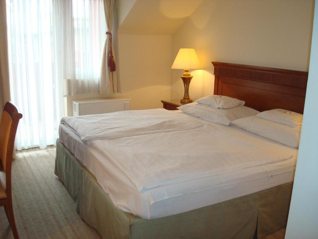 Postel nebo postele na pokoji v ubytování Hotel Romantik Eger